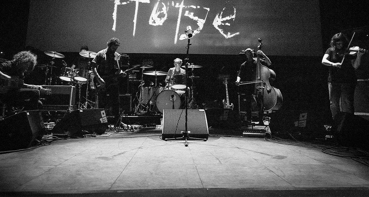 Godspeed You! Black Emperor performing on a dark stage
